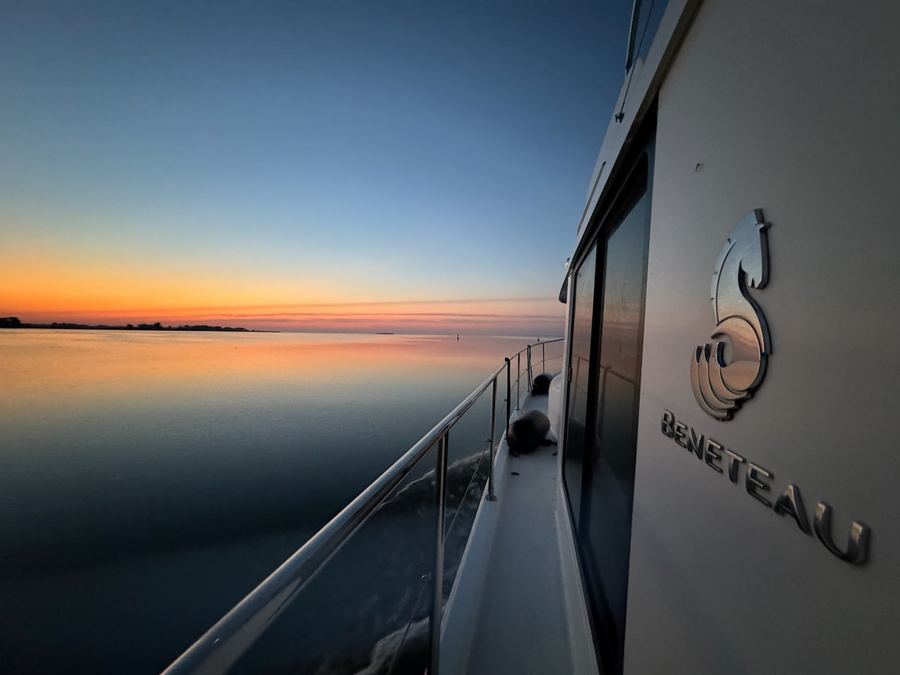 Blick vom Seitendeck einer Motoryacht auf den See im Morgenrot