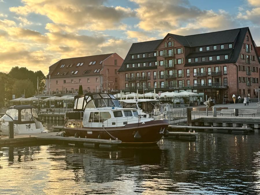 Stadthafen von Waren mit Motoryachten vor historischen Speichergebäuden im Abendlicht