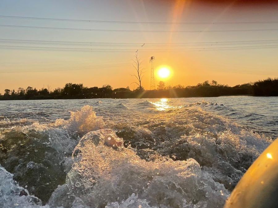 Heckwelle eines Motorboots im Sonnenuntergang